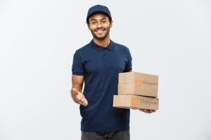 delivery-concept-portrait-happy-african-american-delivery-man-red-cloth-holding-box-package-isolated-grey-studio-background-copy-space(1)